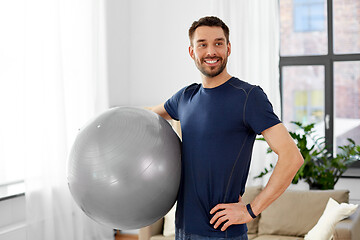 Image showing man exercising with fitness ball at home