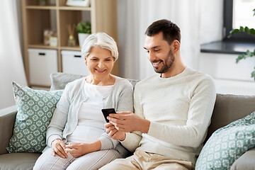 Image showing old mother and adult son with smartphone at home