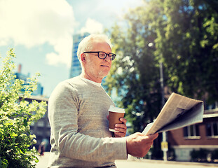 Image showing senior man reading newspaper and drinking coffee