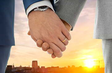 Image showing close up of male gay hands with wedding rings on