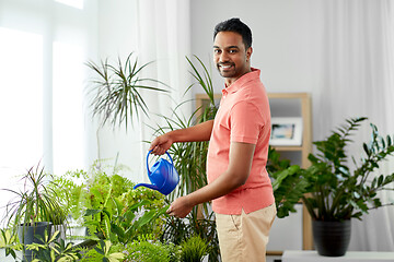 Image showing indian man watering houseplants at home