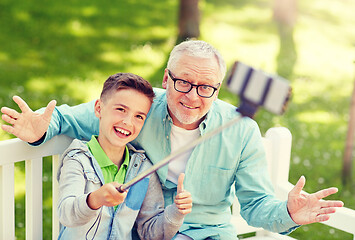 Image showing old man and boy taking selfie by smartphone