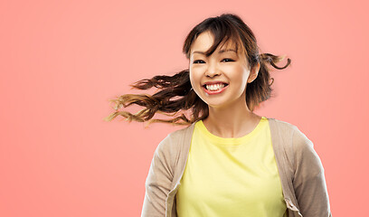 Image showing happy asian woman with waving hair