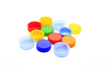 Image showing Multicolored caps from plastic bottles on white background