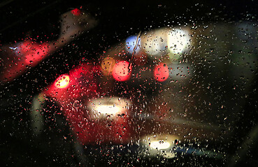 Image showing Lights of night city through the glass of the car with raindrops