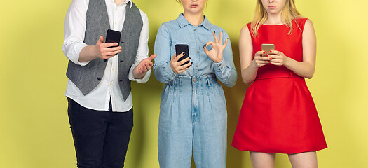 Image showing Group of friends using mobile smartphones. Teenagers addiction to new technology trends. Close up.