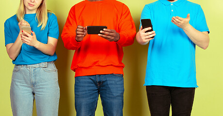 Image showing Group of friends using mobile smartphones. Teenagers addiction to new technology trends. Close up.