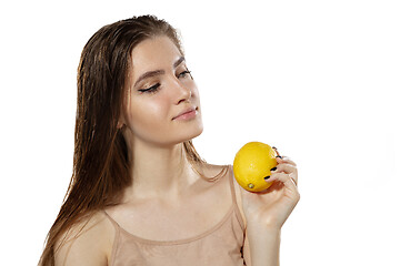 Image showing Youth secrets. Beautiful young woman with lemon over white background. Cosmetics and makeup, natural and eco treatment, skin care.