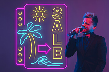 Image showing Young musician, party host singing, dancing in neon light