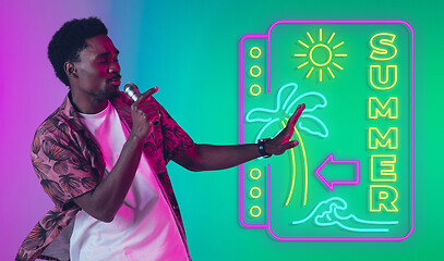 Image showing Young musician, party host singing, dancing in neon light