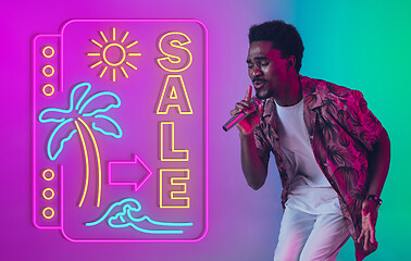 Image showing Young musician, party host singing, dancing in neon light