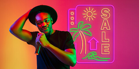 Image showing Young musician, party host singing, dancing in neon light