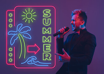 Image showing Young musician, party host singing, dancing in neon light