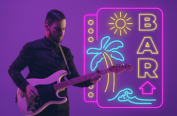 Image showing Young musician playing guitar in neon light on gradient background, inspired, artwork