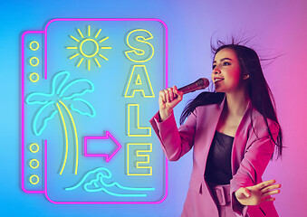 Image showing Caucasian female singer portrait isolated on gradient studio background in neon light with neon sign