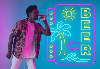 Image showing Young musician, party host singing, dancing in neon light