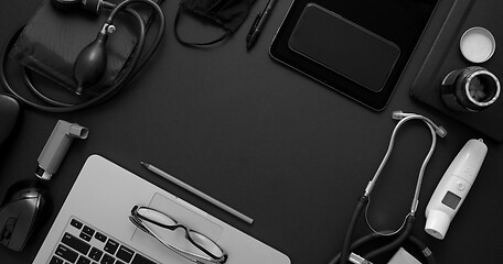 Image showing Doctor desktop concept. Various medical tools and accessories placed on black background table