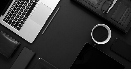 Image showing Business desktop concept. Mix of office supplies and gadgets on a black table background