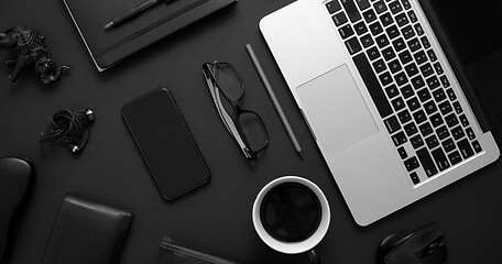 Image showing Business desktop concept. Mix of office supplies and gadgets on a black table background