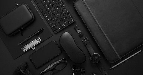 Image showing Business concept. Flat lay composition with various black gadgets on dark black surface