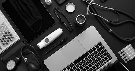 Image showing Doctor desktop concept. Various medical tools and accessories placed on black background table