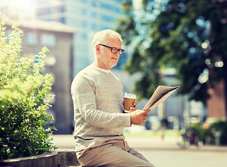 Image showing senior man reading newspaper and drinking coffee