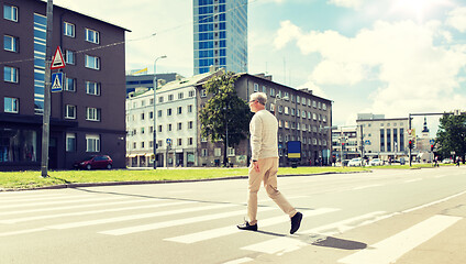 Image showing senior man walking along city crosswalk