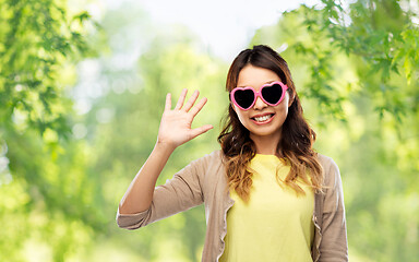 Image showing asian woman in heart-shaped sunglasses waving hand