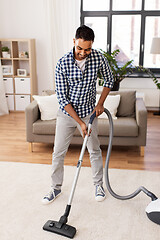 Image showing indian man with vacuum cleaner at home