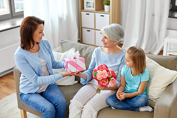 Image showing family giving present and flowers to grandmother