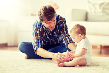 Image showing happy father with baby and piggy bank at home