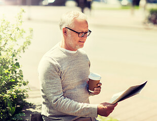 Image showing senior man reading newspaper and drinking coffee