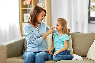 Image showing mother and daughter sitting on sofa at home