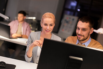 Image showing business team with computer working late at office