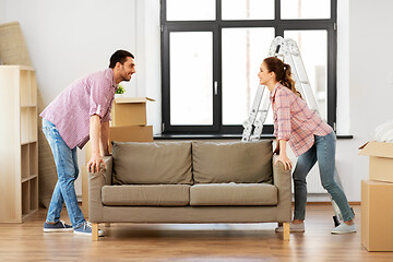 Image showing happy couple moving sofa at new home
