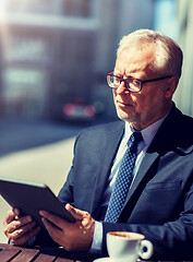 Image showing senior businessman with tablet pc drinking coffee