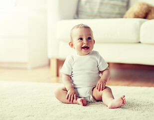 Image showing happy baby boy or girl sitting on floor at home