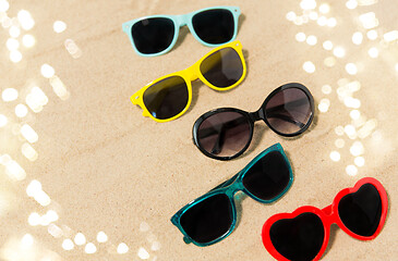 Image showing different sunglasses on beach sand