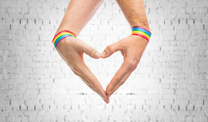 Image showing male hands with gay pride wristbands showing heart