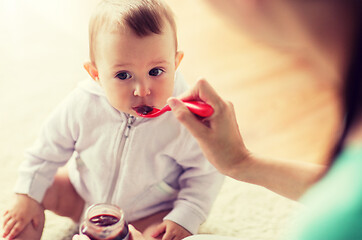 Image showing mother with spoon feeding little baby at home