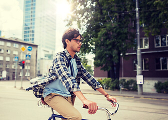 Image showing young hipster man with bag riding fixed gear bike