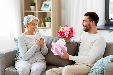 Image showing son giving present and flowers to senior mother