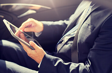 Image showing senior businessman with tablet pc driving in car