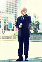 Image showing senior businessman calling on smartphone in city