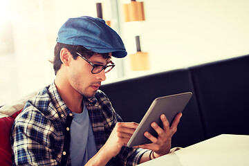 Image showing man with tablet pc sitting at cafe table