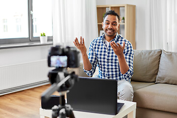 Image showing male blogger with camera videoblogging at home