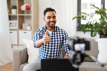 Image showing male blogger with camera videoblogging at home