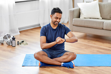 Image showing smiling indian man with fitness tracker at home