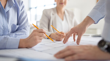 Image showing close up of architects with blueprint at office