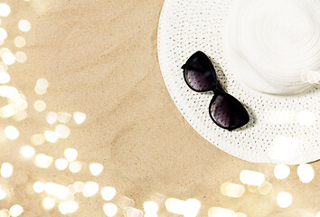 Image showing straw hat and sunglasses on beach sand